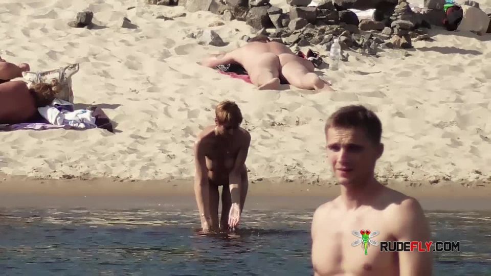 Long haired hottie lays around nude at the  plage