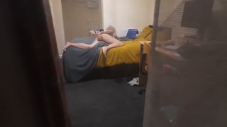Spying through the window voyeur horny blonde girl masturbating on the bed while watching laptop porn - Amateur