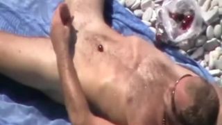 She licks his moist balls on the beach